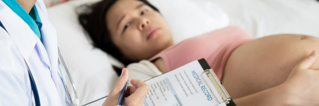 Doctor reviewing pregnant patient's records.