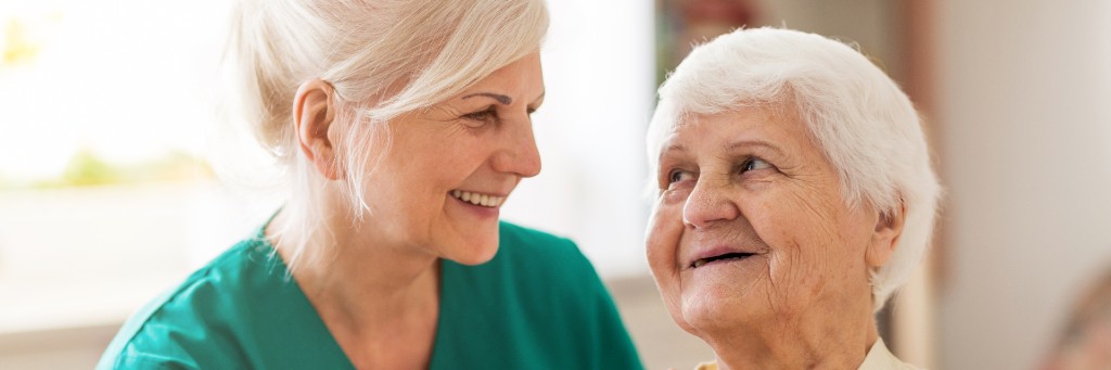 Two women smiling warmly together.