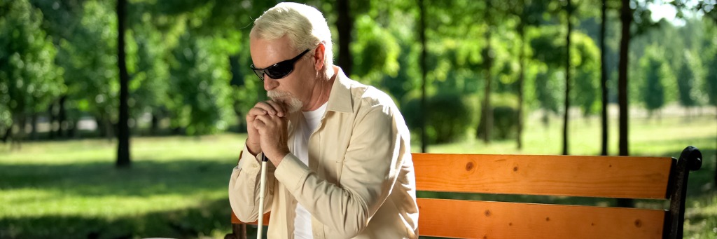 a man sitting on a bench with his hands clasped together