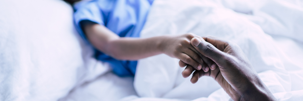 Parent holding hand of sick child