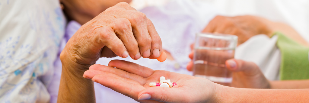 Elderly hand reaching for pills