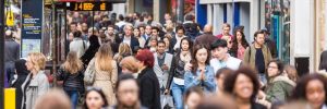 Crowded street with pedestrians walking.