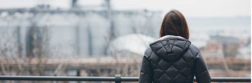 Person in coat overlooking cityscape.