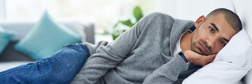 Man lying on sofa, relaxed.