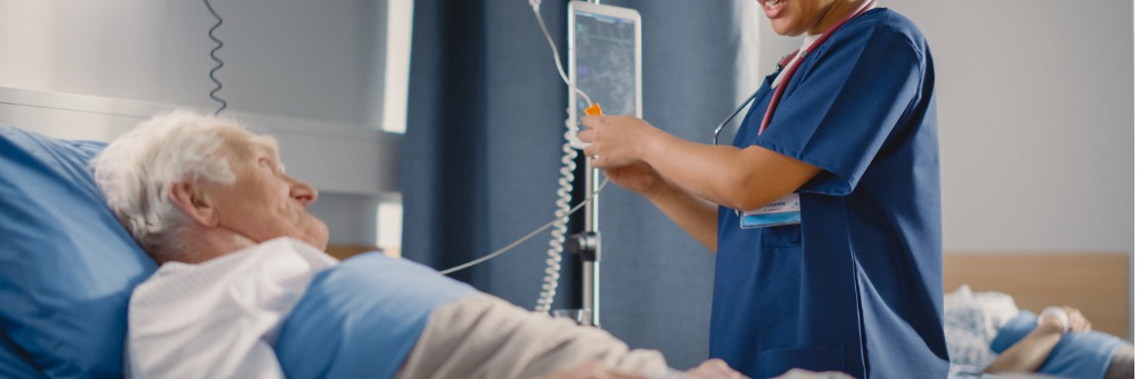 Nurse adjusting patient's IV drip.