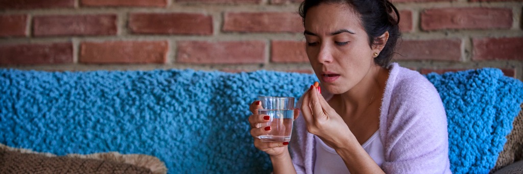 Woman taking medication with water.