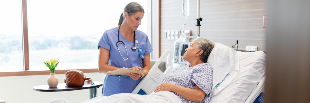 Nurse consulting with hospital patient.