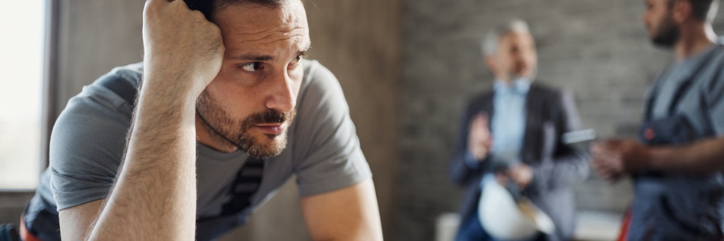 Pensive man with colleagues talking.