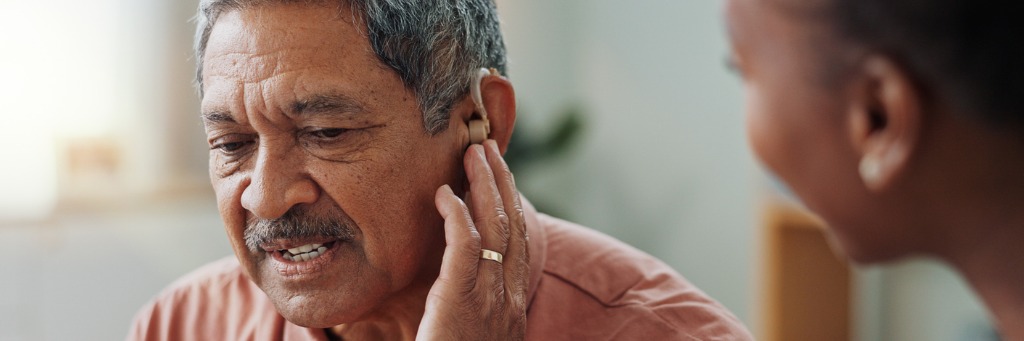 Man adjusting his hearing aid.